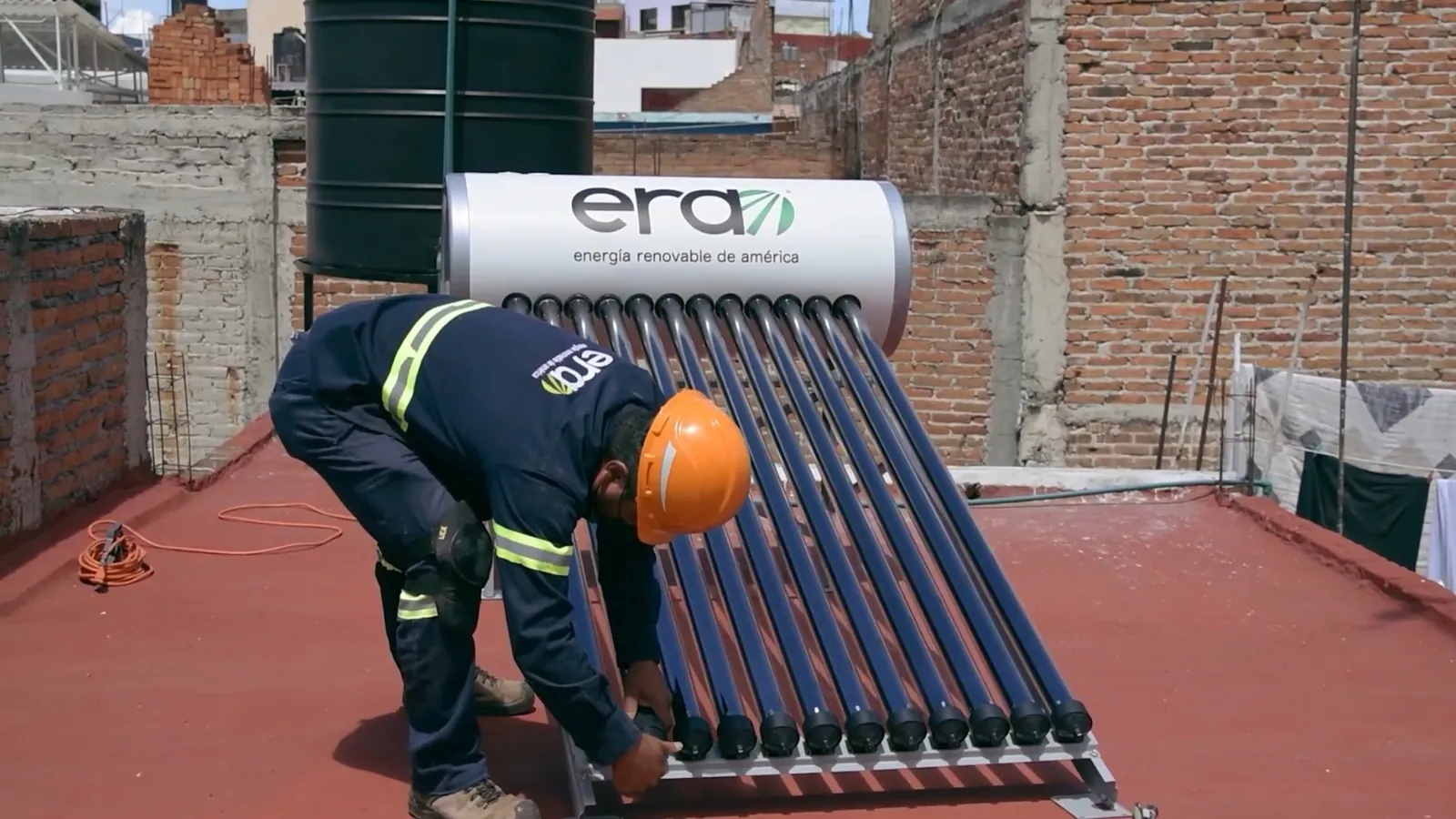 Instalador con casco colocando un calentador solar ERA en una azotea