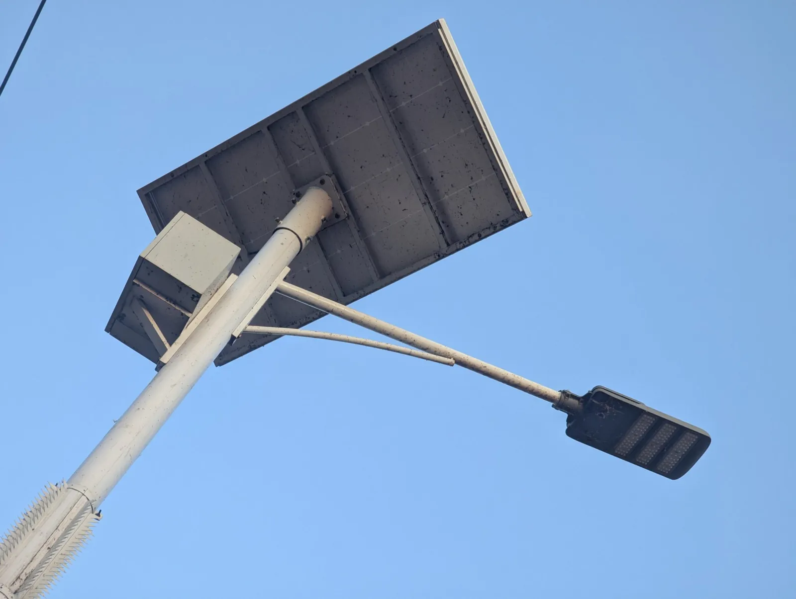 Luminaria solar con su panel en lo alto de un poste, contra el cielo