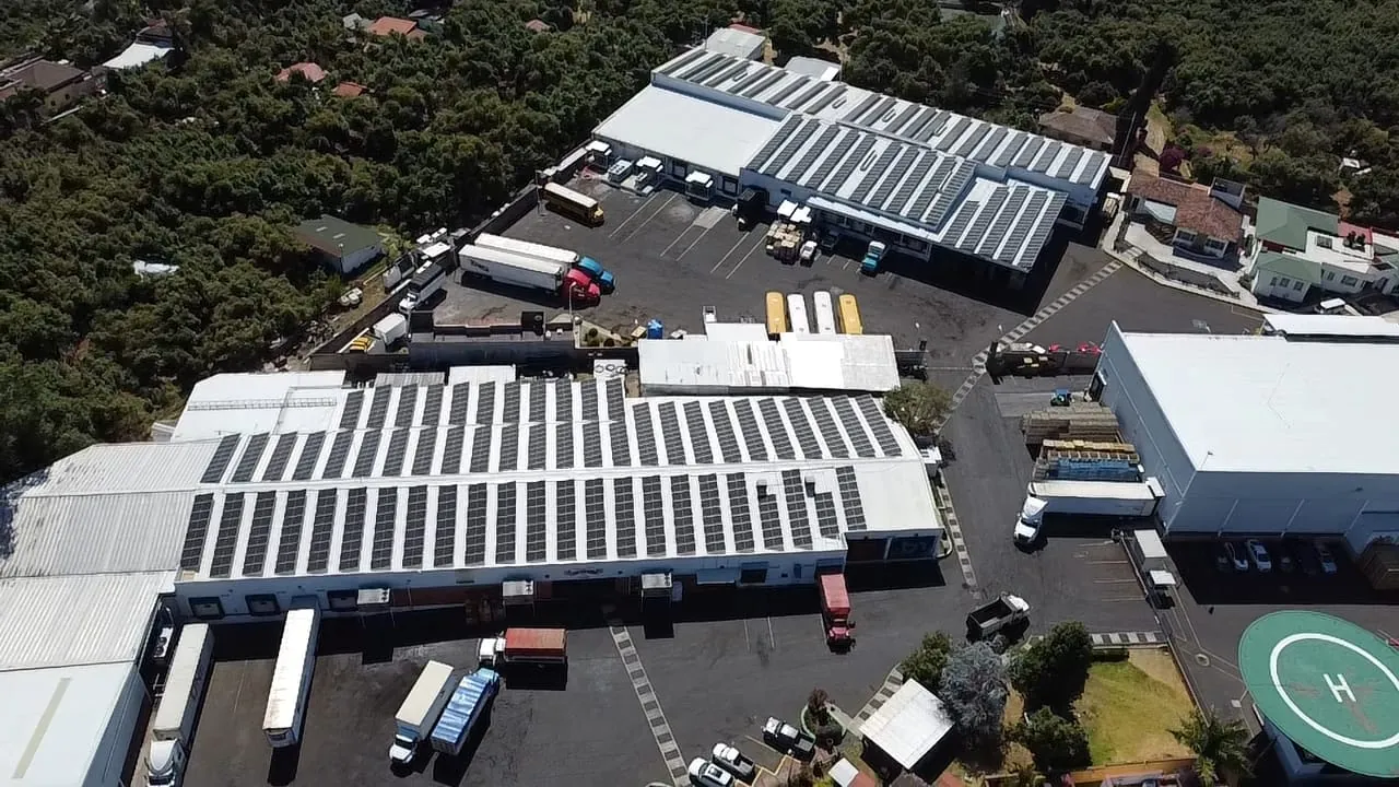 Vista de dron de paneles solares sobre los techos de varias naves industriales